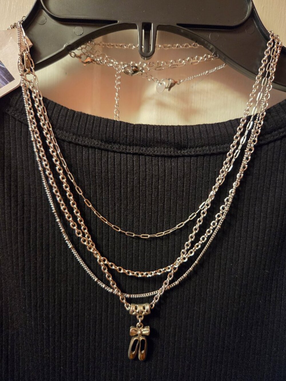 Multiple slivertone Necklaces one has a pair of Ballet Slippers.
